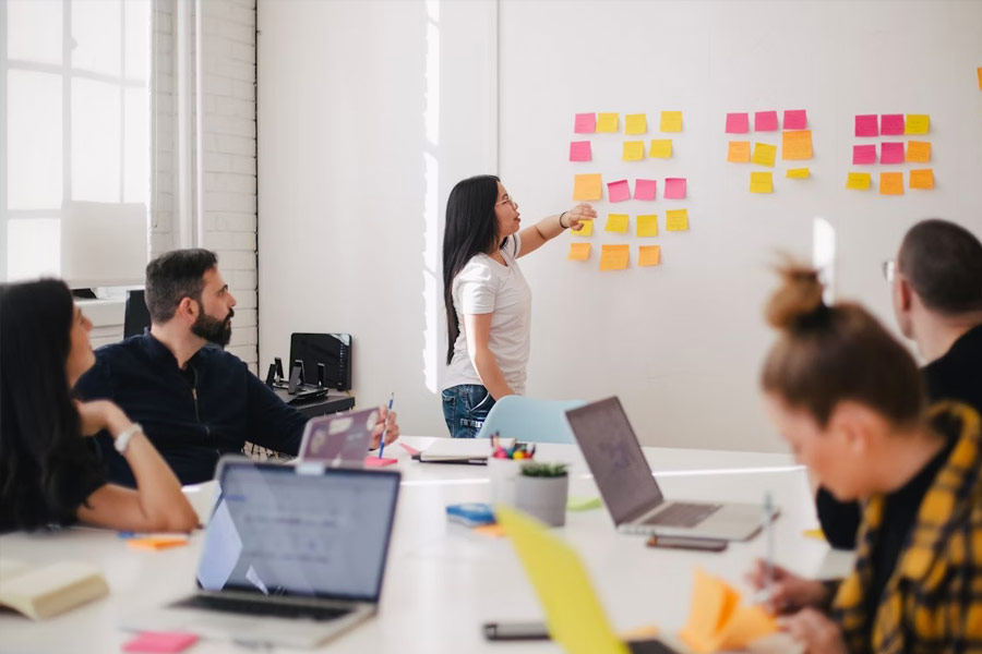 A team discussing priorities using sticky notes on a wall